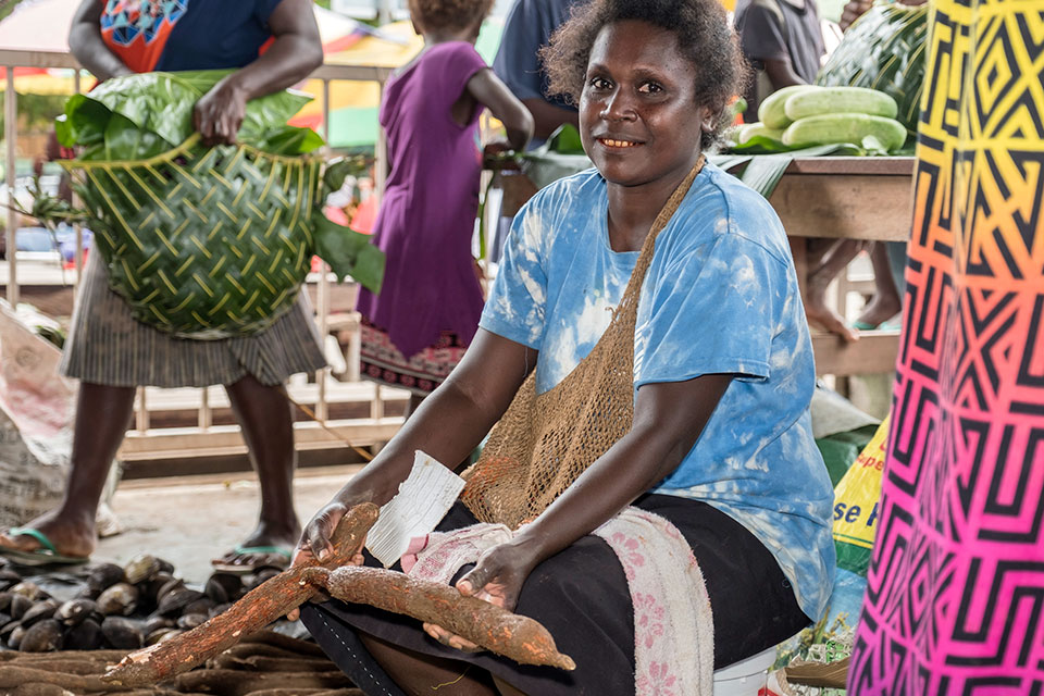 Market vendor Betty Ringili with the cassava she sells at Gizo Market. Photo: UN Women/ Andrew Plant