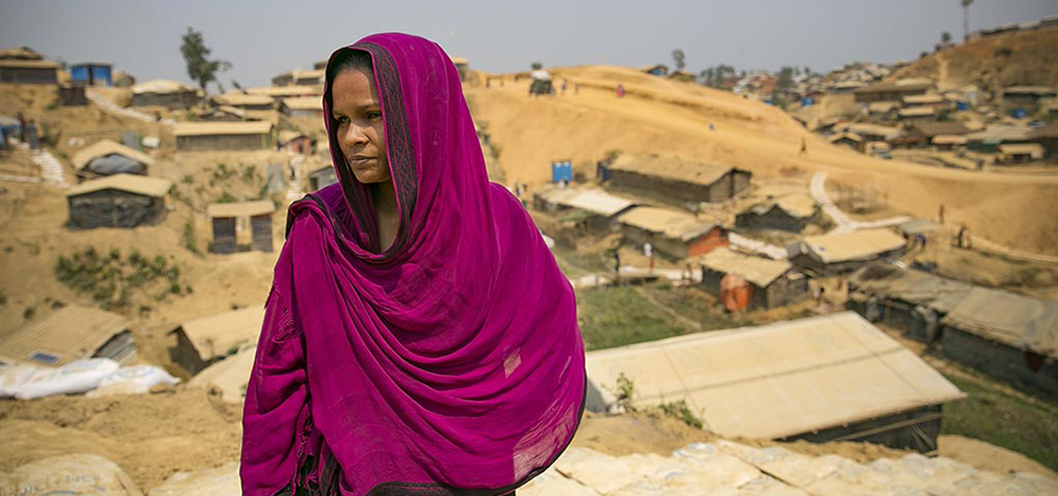 A Rohingya woman refugee stands in a refugee camp in Bangladesh after fleeing violence in Myanmar. Photo: UN Women/Allison Joyce