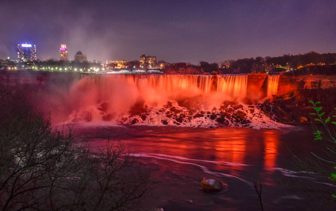 Niagara Falls, both American and Canadian Horseshoe falls, bathed in orange light on 24 November 2015. Photo: UN Women/James Neiss