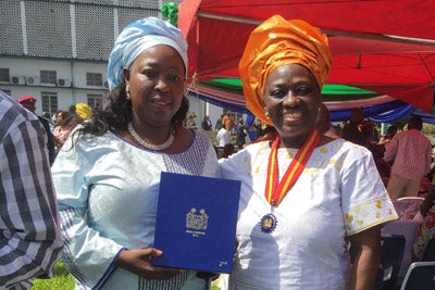 Baindu Massaquoi, UN Women Programme Specialist who was seconded to the United Nations Mission for Ebola Emergency Response during the emergency , and  Mary Okumu, UN Women Representative for Sierra Leone, accept a Silver Medal, honoring work during the Ebola crisis,  awarded to UN Women by the President of Sierra Leone on 18 December 2015 at the State House in Freetown Sierra Leone. Photo: UN Women