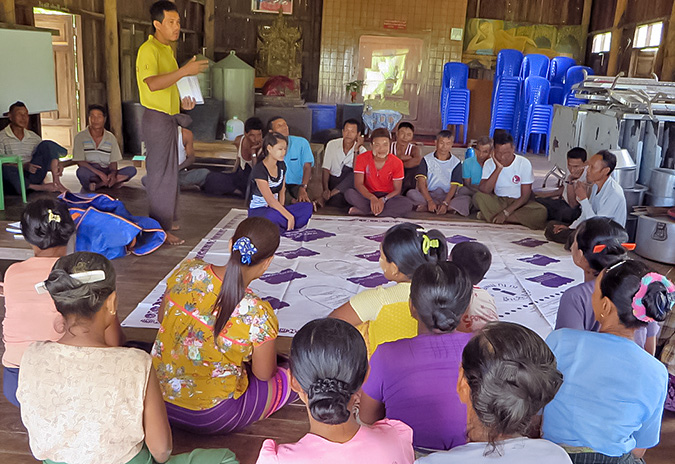 At a community gathering, Tin Moe Tun uses an ActionAid toolkit game to get fellow villagers involved in a discussion on women’s rights. Photo: ActionAid Myanmar