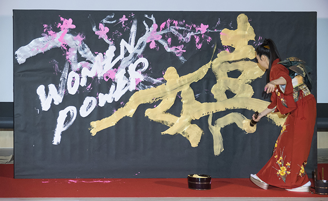 Yuuna Okanishi dramatically stylized calligraphy on stage to live piano music provided by Takashi Matsunaga. Photo: UN Women/STORY CO., LTD