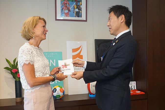 UN Women Deputy Executive Director Asa Regner gifts a HeForShe pin to the Commissioner of Japan Sports Agency, Mr. Daichi Suzuki, and seeks his support to promote gender equality in sport. Photo: UN Women