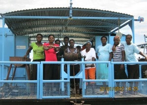 Ten fisherwomen stand aboard their rig on Lake Kariba, Zimbabwe. Photo Credit: UN Women/Memory Zonde-Kachambwa