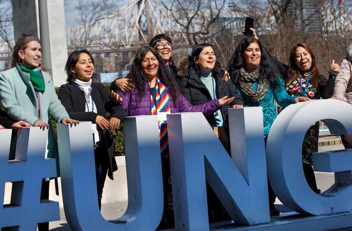 Women are seen with the UN General Assembly sign.