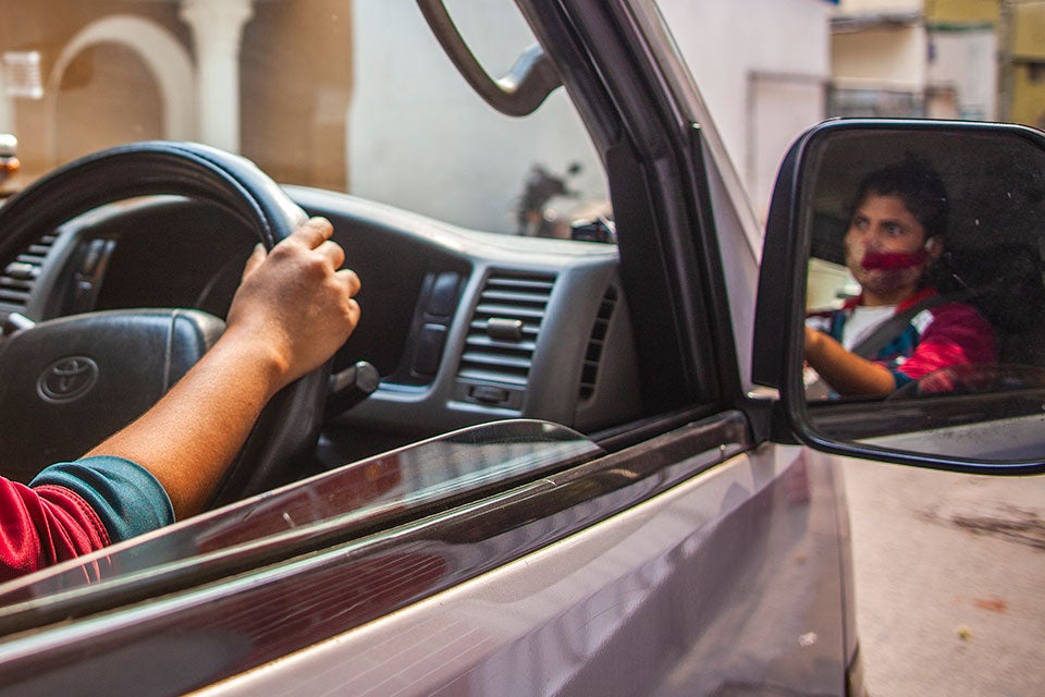 Romela's hands on the steering wheel as she drives. 