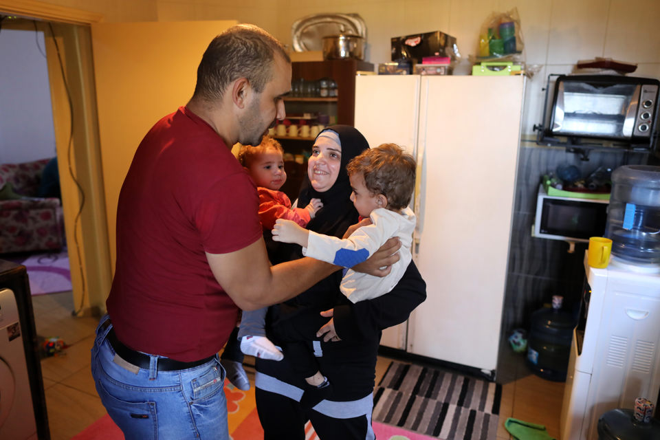Ahmed Moustafa, a school principal, and Samiha Ghimrawi, a science teacher, at home in Tripoli, Lebanon, with their two children. Photo: UN Women/Marwan Tahtah.