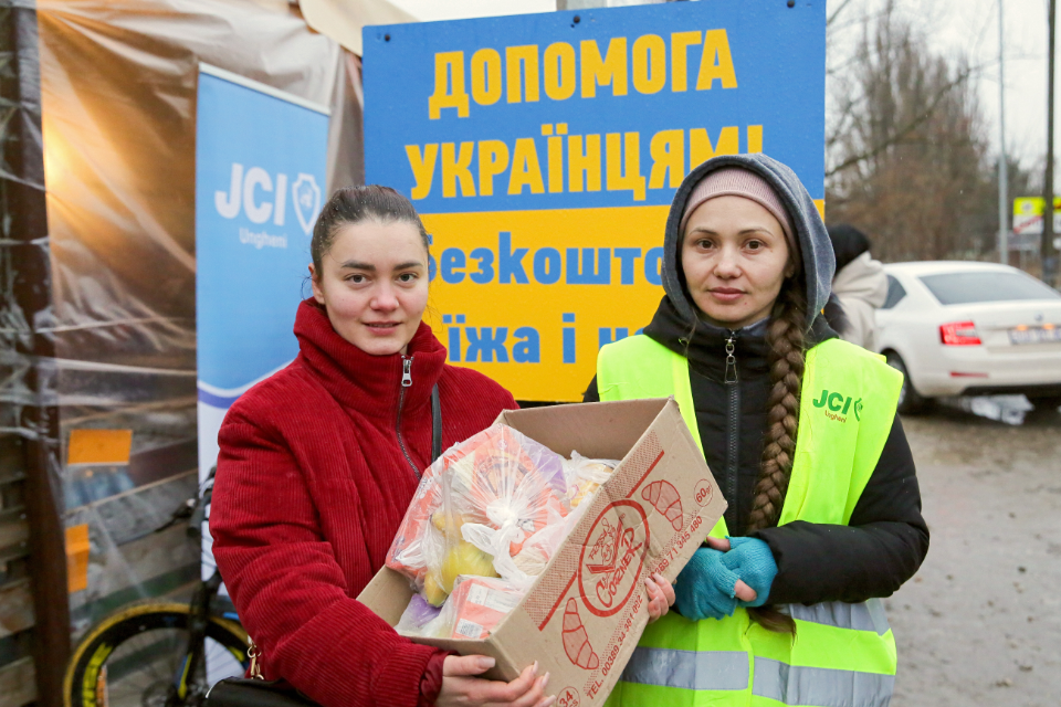 Voluntarios de la JCI Ungheni repartiendo bolsas de comida a las personas refugiadas que pasan por la aduana de Sculeni. Fotografía: ONU Mujeres Moldova