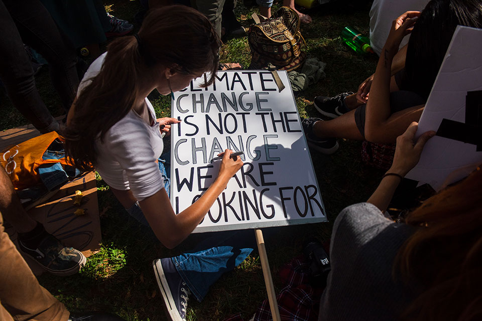 A young woman in New York prepares a protest sign as part of the youth-lead global Climate Strike in September 2019.   Photo: UN Women/Amanda Voisard