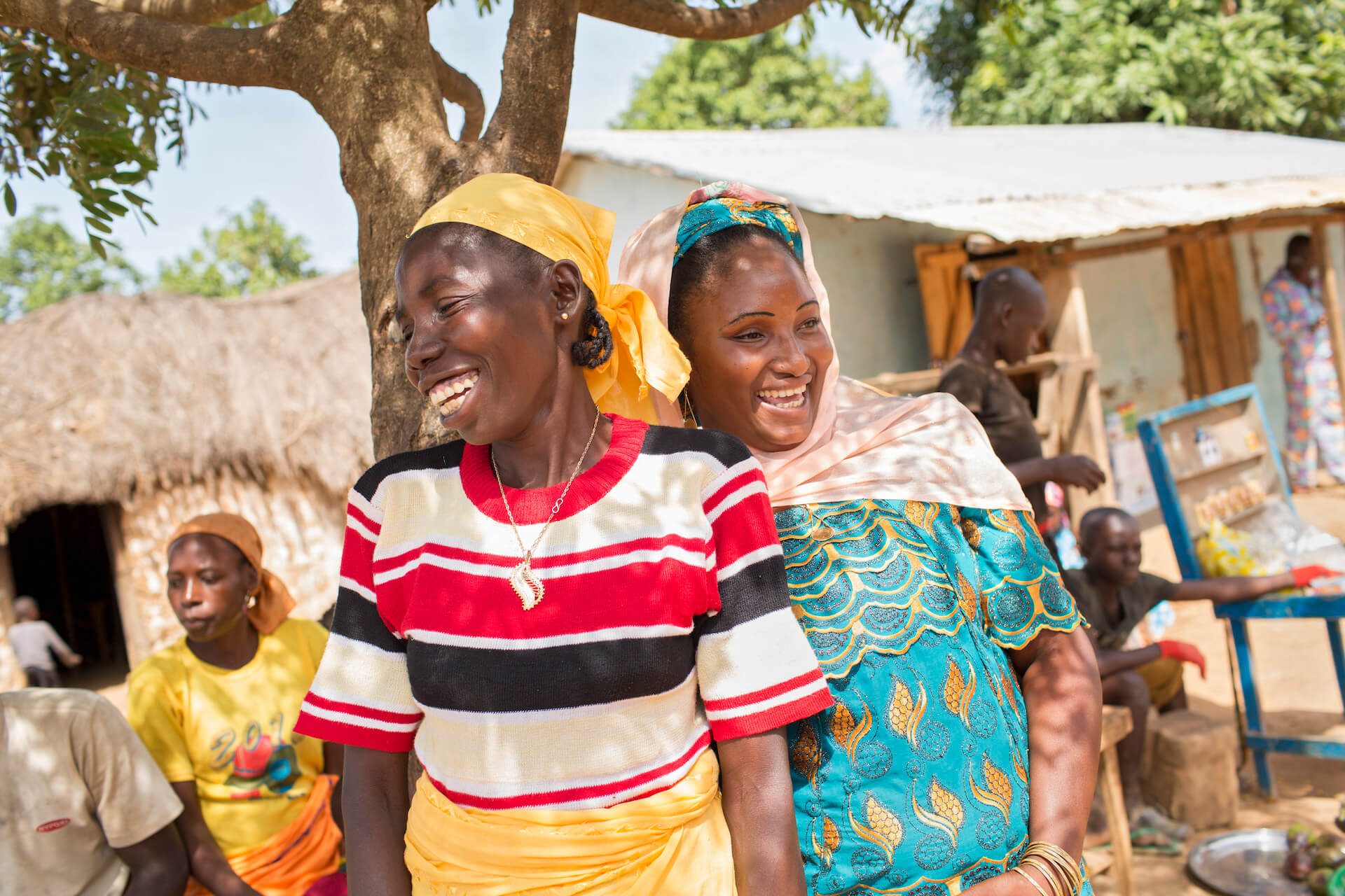 En Camerún, ONU Mujeres trabaja con las comunidades que albergan campos de refugiados, capacitando a mujeres locales en el pequeño comercio, procesamiento de alimentos, costura, fabricación de jabón, gestión de proyectos y emprendimiento. Rebecca (izquierda) y Ouseina (derecha) recibieron capacitación empresarial y una pequeña subvención de ONU Mujeres, y ambas trabajan como vendedoras de una variedad de alimentos calientes, incluidos estofados de carne y platos de mandioca.