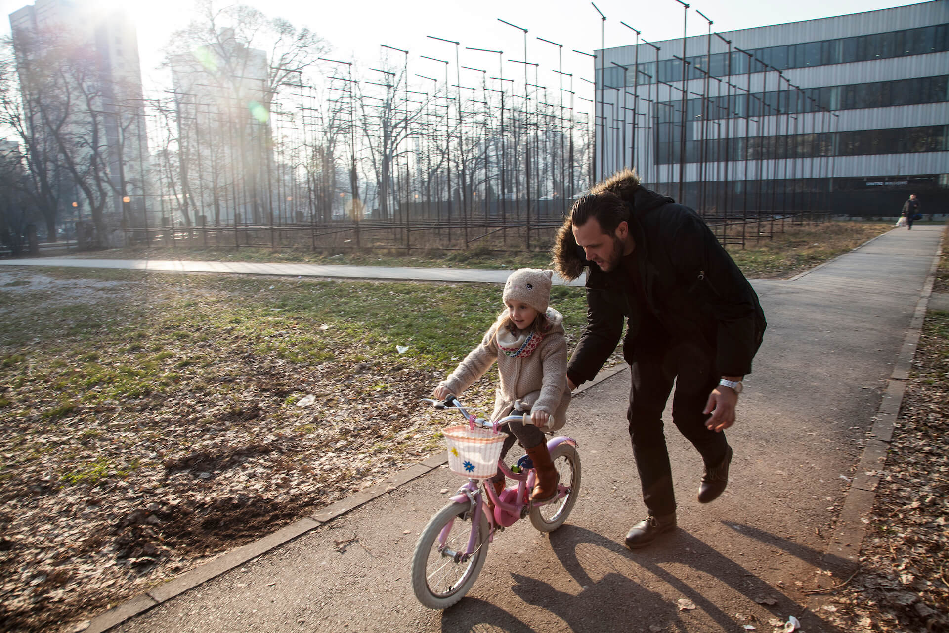 Nihad Hasanović le enseña a su hija Enea, de 5 años, a andar en bicicleta. Nihad es un padre que se queda en casa, cuya esposa trabaja en horario de oficina durante el día.