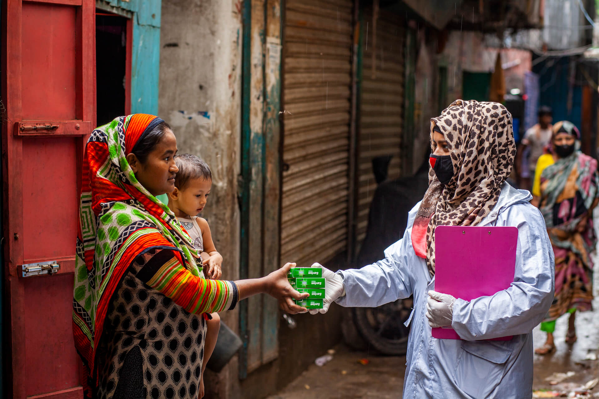 Tanzima Akter works as a community facilitator under the LIUPC project of UNDP Bangladesh. Here she is distributing anti-bacterial and disinfecting soap to a family in Dhaka. Photo: UN Women/Fahad Abdullah Kaizer