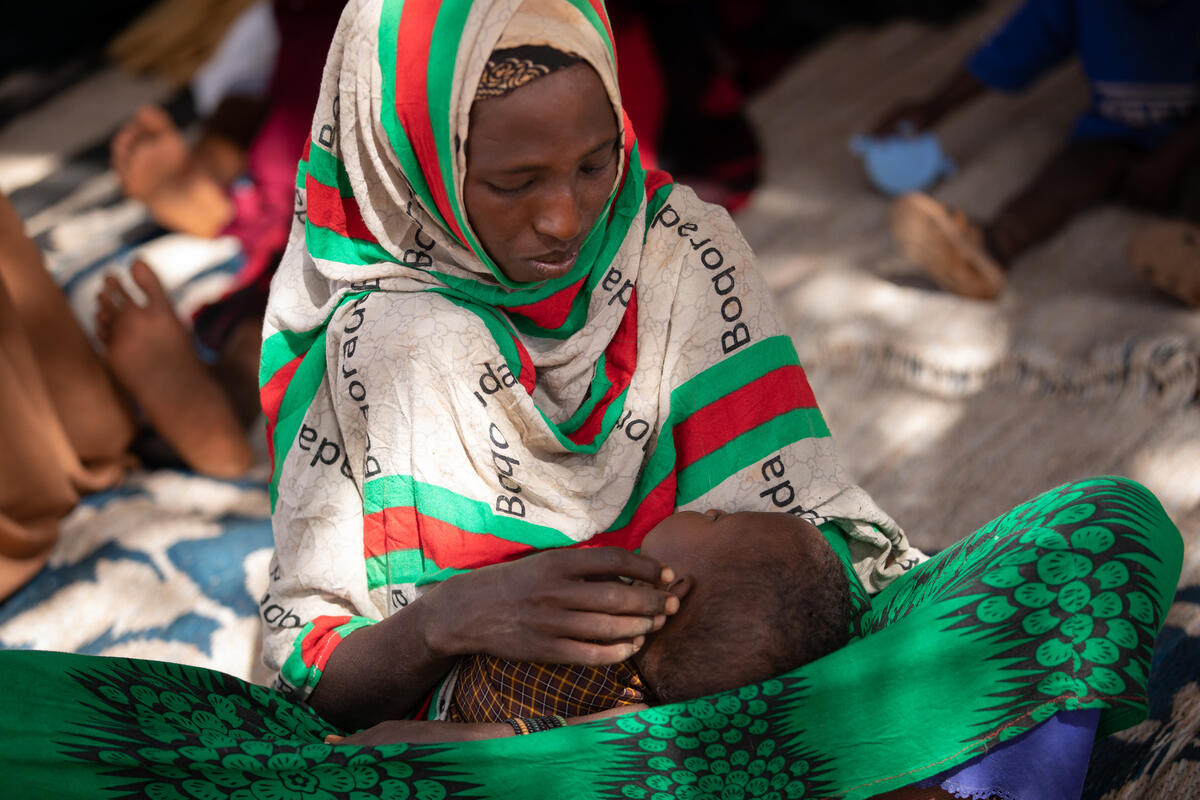 A Somalian woman, displaced by drought and the threat of famine, holds her child. In Somalia and other crisis-affected areas, grain shortages driven by the war in Ukraine are compounding food insecurity. Photo: WFP/Samantha Reinders
