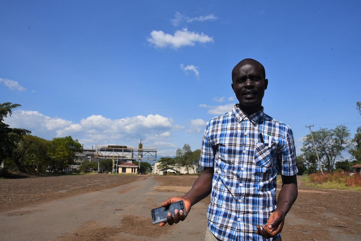 Oscar Ochieng, de 35 años, explica la dinámica de conflicto de la región frente a una fábrica de azúcar casi abandonada. Este abandono ocasiona el aumento del crimen y del robo de mercaderías. Fotografía: ONU Mujeres/Luke Horswell