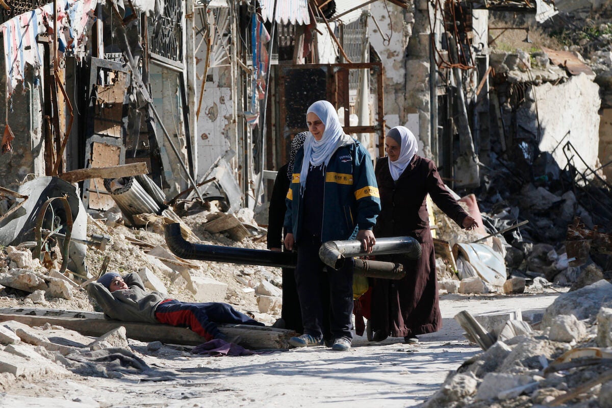 Des femmes récupèrent des matériaux utilisables dans des parties endommagées de la place Al-Hatab dans le vieux quartier d’Alep, au nord de la Syrie, février 2017. Photo : EPA/Youssef Badawi