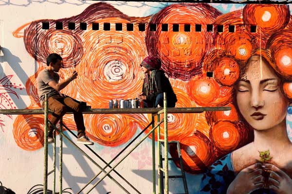 A group of graffiti artists (all young women) painted orange murals in Zone 18 in Guatemala City in support of UN Women and the UNiTE campaign to End Violence against Women. Photo: UN Women/Carlos Rivera