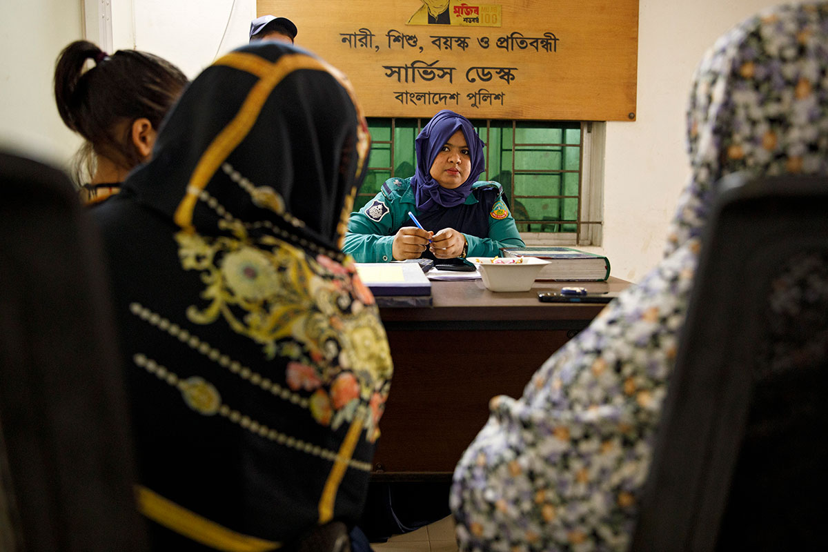 At the help desk specifically created to serve women, children, disabled persons, and elderly in Tongi Station in Dhaka, Bangladesh, Assistant Sub Inspector Fatima of the Dhaka Metropolitan Police receives testimony from a member of the community lodging a case. 