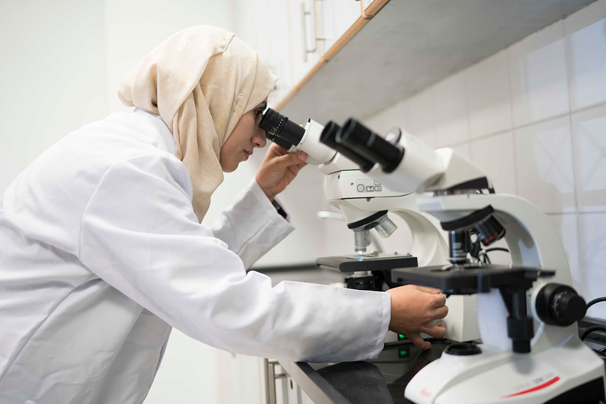 Forensic science laboratory expert Rawan Tomalieh conducts a microscopic examination in Ramallah, West Bank in 2019.