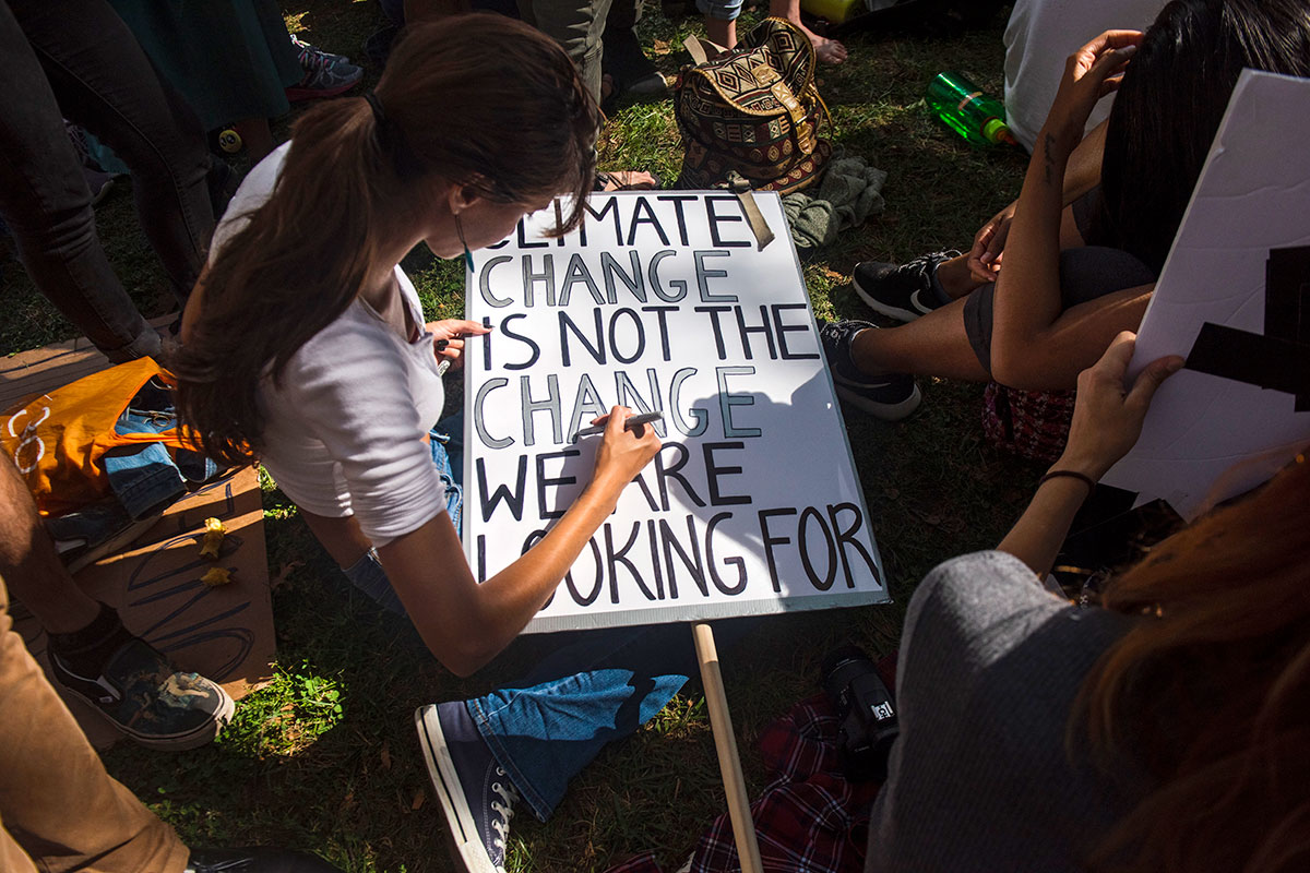 Lors d’une manifestation dans le centre-ville de New York dans le cadre de la grève scolaire mondiale pour le climat #ClimateStrike en 2019, une participante crée une bannière portant la mention : « Climate Change is not the Change We Are Looking For »
