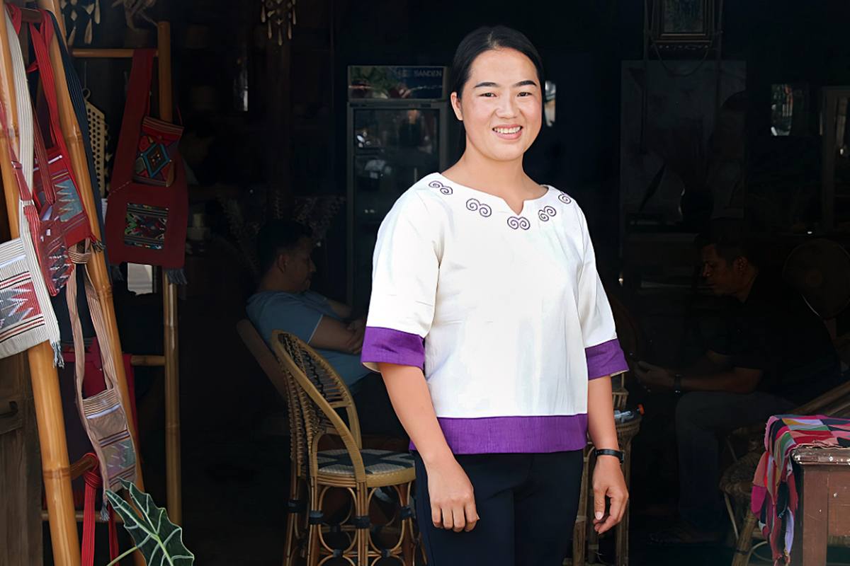 Hua Sae-Wue porte une chemise qu’elle a fabriquée et pose devant le Centre WEE dans le district de Chiang Kong, dans le nord de la Thaïlande. 