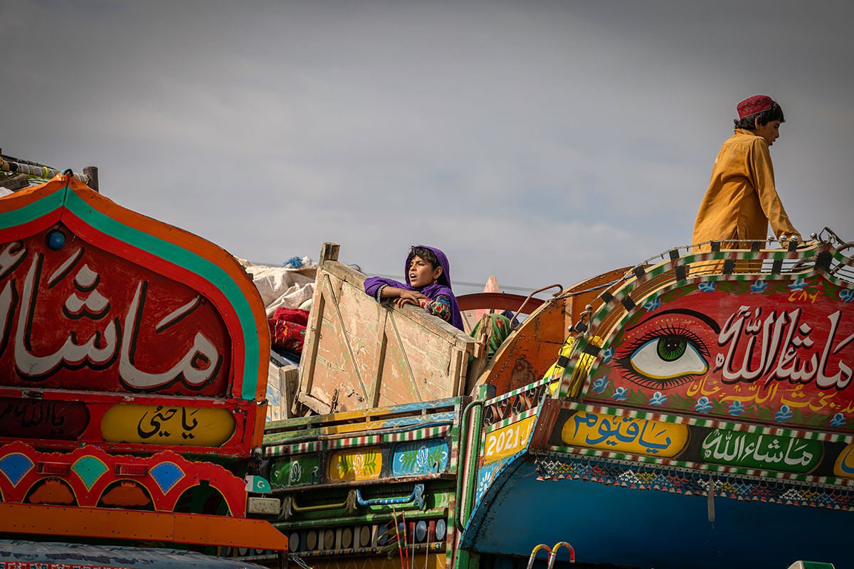 A young Afghan girl waits for her family to receive assistance at the Spin Boldak border crossing. Photo: IOM/Mohammad Osman Azizi.