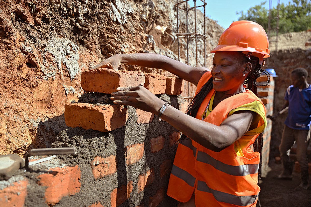 Grace Poni, a South Sudanese refugee works on a construction site in Arua, northern Uganda. Thanks to UN Women and partner Refugee Law Project, Grace and other refugees in the area got technical skills that they're using to improve their lives.