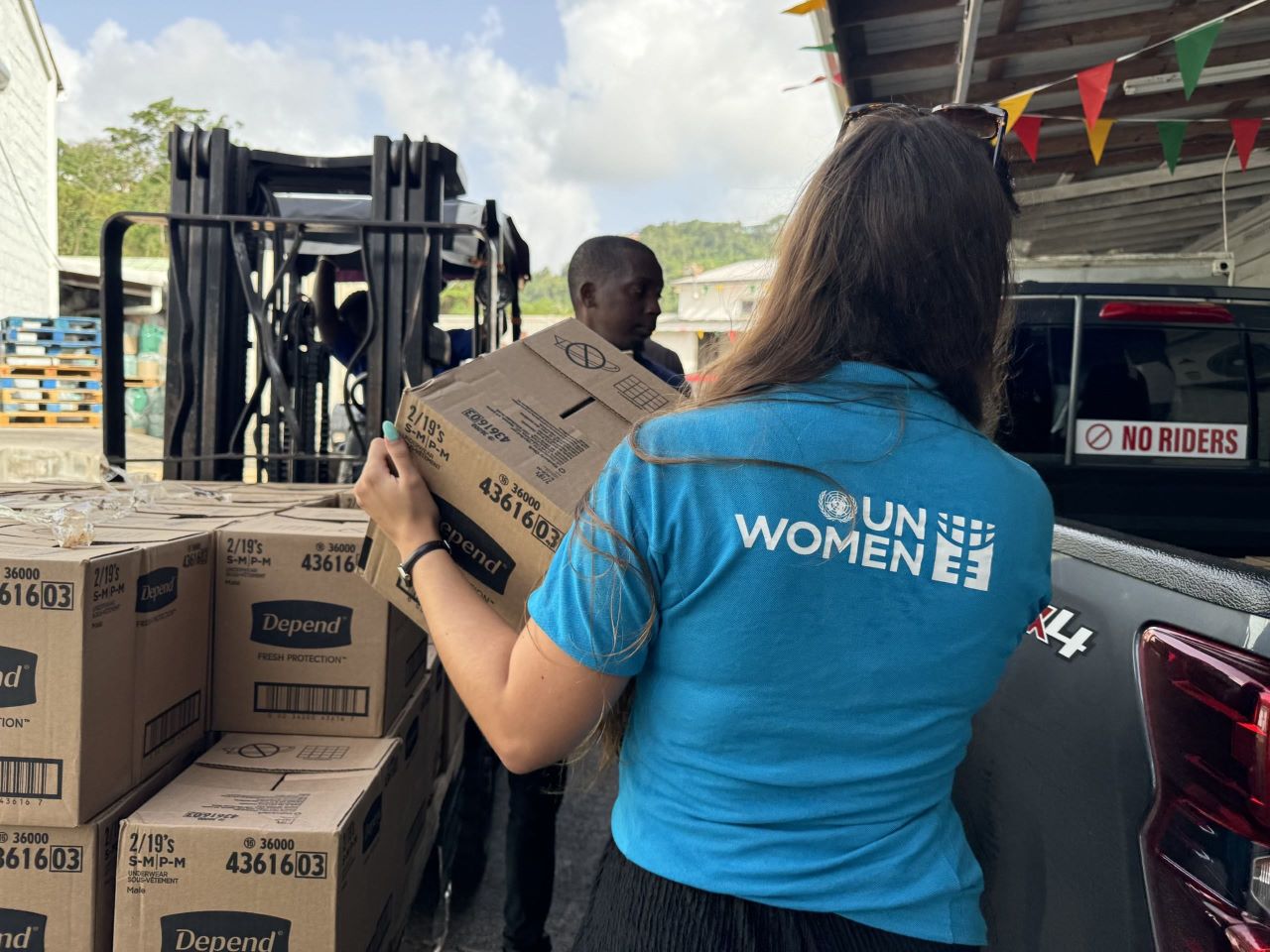 A member of UN Women’s team helps load items designated for the Share the Care Packs to be distributed in Grenada.