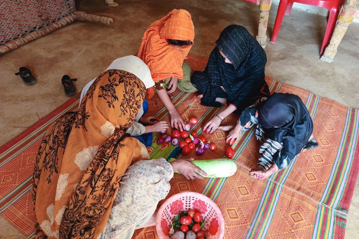 Photo de Yasmin Gul avec ses filles et sa petite-fille en train de faire des corvées ménagères. Photo : ONU Femmes