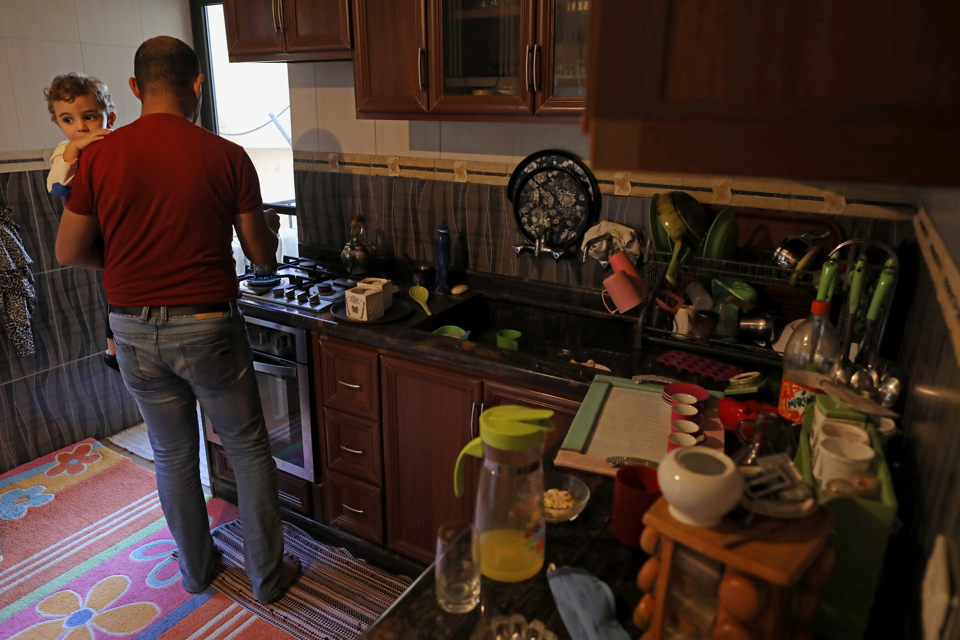 Ahmed Moustafa prepares food in the kitchen of his family home. Photo: UN Women/Marwan Tahtah.