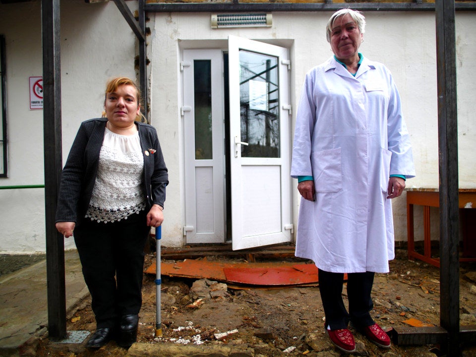 Elena in front of the village medical centre with a staff member who has treated her since she was a child.