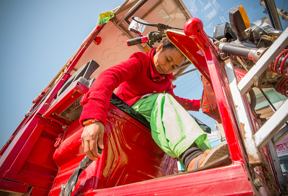 Padma Chaudhary prepares to start her day after taking her e-rickshaw out from a rented shed in Dhangadhi bazaar, where she parks it at night before returning home to Phulwari. Photo: UN Women/Merit Maharjan