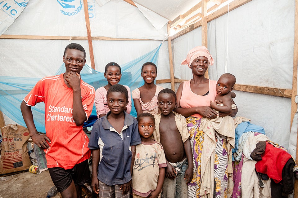 Luscie with her children. Many women in the camp are widows and have had to become heads of their households, taking on the responsibility for the children, the sick or the elderly. They need services and resources. Through the multipurpose centres, nearly 300 women in Lusenda have gained temporary employment through cash-for-work programmes. Another 80 women and girls acquired soap-making skills and 38 learned how to operate a camp restaurant.  Photo: UN Women/Catianne Tijerina