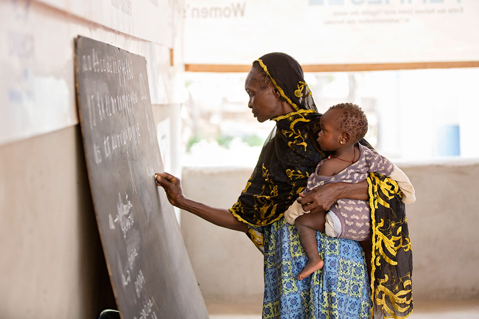 A refugee from CAR learns the French alphabet as part of an adult education class held at the UN Women Social Cohesion space. Photo: UN Women/Ryan Brown