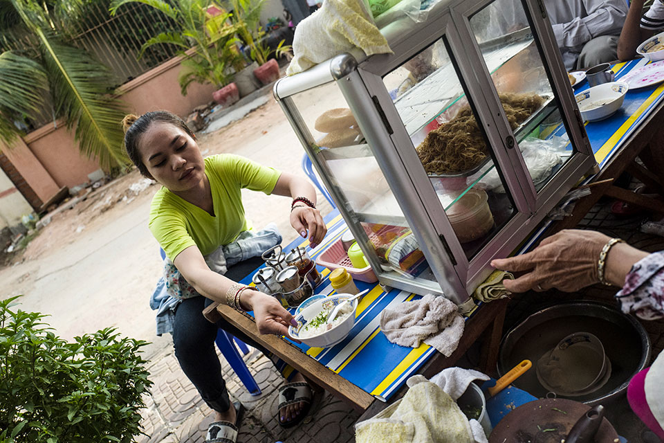 Srey Sros stops for breakfast near her small rented room in Phnom Penh. Photo: UN Women/Charles Fox