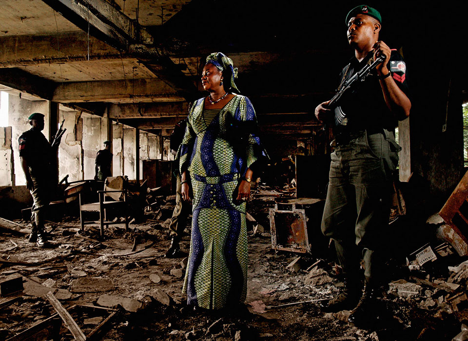NIGERIA. Lagos. 2006. Dora Akunyili, Director of the National Agency for Food and Drug Administration and Control, stands in the charred remains of her former office, torched by arsonists in 2004. In 2003 she survived an assassination attempt by gunmen with AK-47s. Today, the insurgent group Boko Haram has killed civilians, abducted women and girls, and destroyed homes and schools. In countering the rise of violent extremism, women’s participation helps: they are often the first to identify signs of radicalization and act to intervene. ©Alex Majoli/Magnum Photos