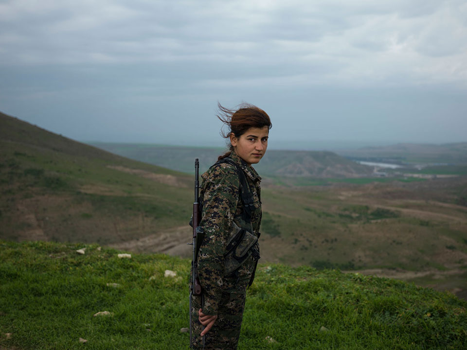 SYRIA. Semalka Border. 2015. Torin Khairegi, 18, member of a Kurdish group of female soldiers who have taken up the fight against ISIS. The Syrian conflict has grown in intensity for more than two years, leading to millions of displaced and an estimated over 200,000 dead. While some Syrian women have worked to promote peace talks and conflict resolution, the conflict has also seen the participation of women in armed groups, including among Kurdish fighters. Understanding the myriad of roles women play in conflict is essential to address the root causes of conflict and design sustainable disarmament and reintegration programs that respond to their needs.  ©Newsha Tavakolian/Magnum Photos