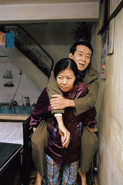 VIETNAM.Hanoi. 2004. A woman carries her 52-year-old war veteran husband who lost the use of his legs in 1973. Women in conflict and post-conflict settings continue their roles as caregivers. Conflict leaves them often at the head of a household, taking care of the elderly, the wounded and the children. Recovery programmes need to recognize this population, and be gender-tailored to support women and their family’s well-being.  ©Patrick Zachmann /Magnum Photos