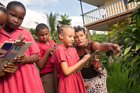 Christel Jacques, 55, leads her Wildlife Club of 8-year-old children on an outing to learn about mangroves. Photo: UN Women/Ryan Brown