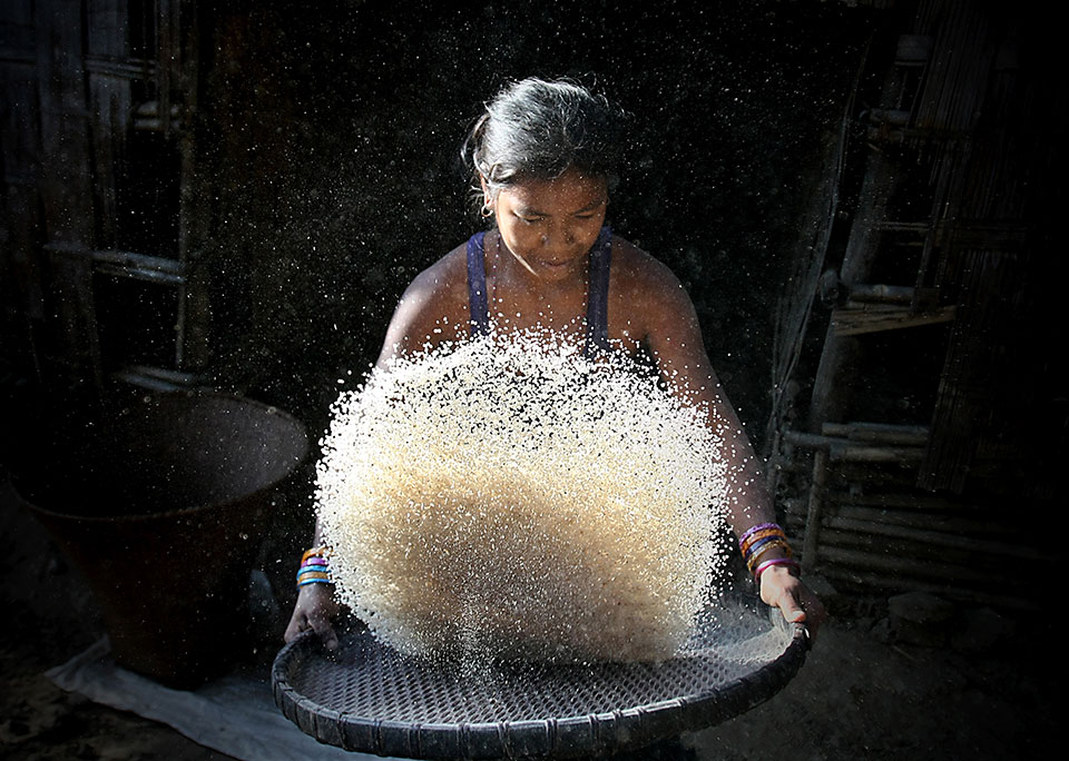 In a remote village in Bangladesh, a young woman sorts rice. Her harvest must last a long time, as the weather usually allows cultivation only once a year.  Photo: UNDP/Jashim Salam