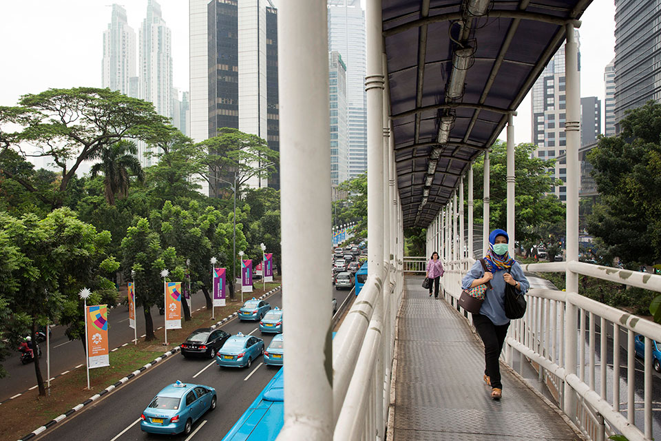 Pedestrians use an elevated walkway to access public transportation in Jakarta, Indonesia. Photo: UN Women/Ryan Brown