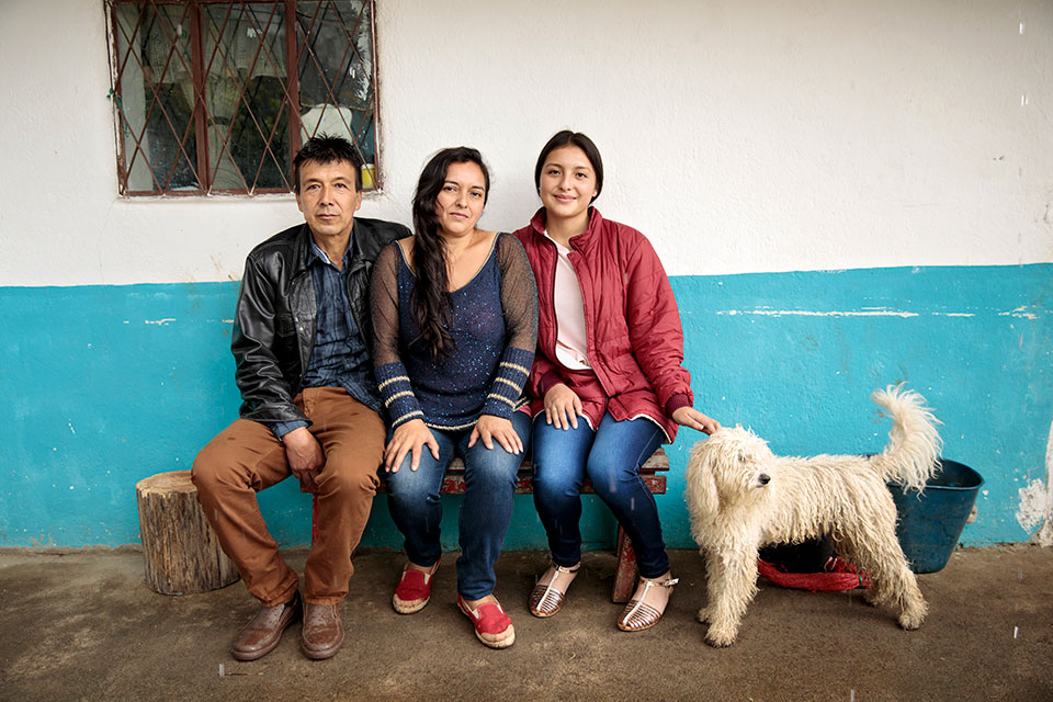 Cielo Gomez (center) and her family live in the municipality of El Tablón de Gómez, in the southeast of Nariño territory, Colombia.  “Both of us are now land owners and that’s economic autonomy,” says a proud Cielo. Since then, she has taken a loan from the bank and bought another piece of land. Photo: UN Women/Ryan Brown