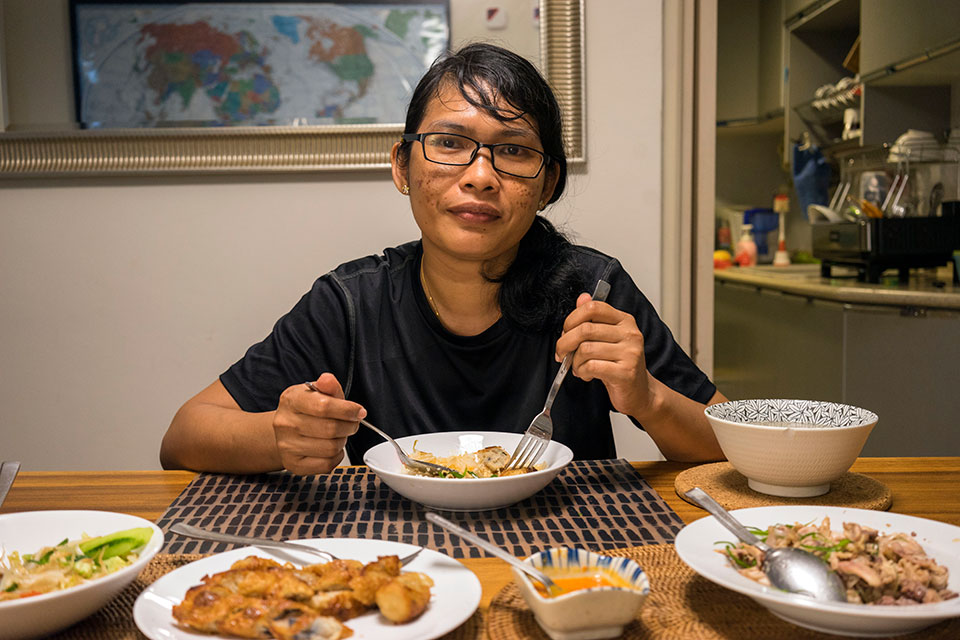 Sammi Gunawan, a 38 year old Indonesian domestic worker in Singapore, eats her last meal of the day before her evening prayers, at the end of her working day. Photo: UN Women/Staton Winter