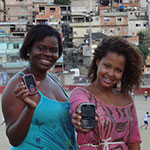Girls display a mobile app against violence in a shantytown in Rio de Janeiro, Brazil