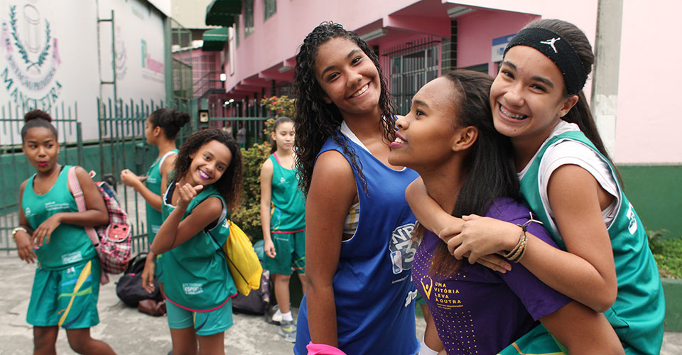Three girl participants in the ‘One Win Leads to Another’ in Brazil celebrate during a basketball game. Photo: UN Women/Gustavo Stephan