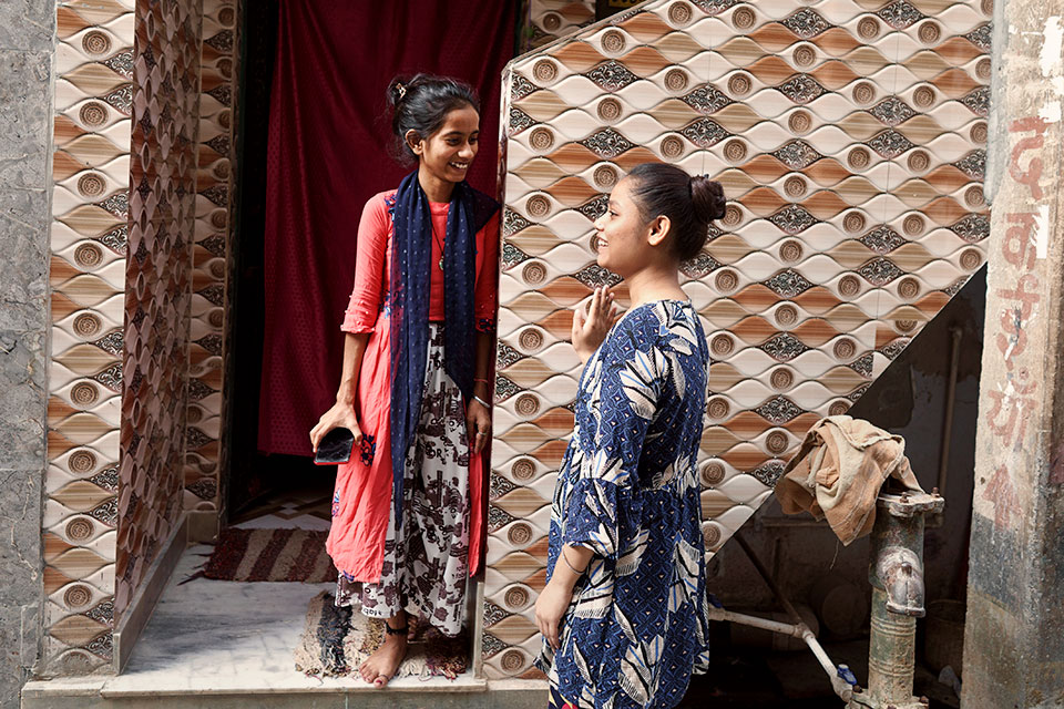Lakshmi, 19, (in red) and Vidhi, 17, in the Bhalswa Dairy community in Delhi, India.  June 2021.    Photo: UN Women/Ruhani Kaur