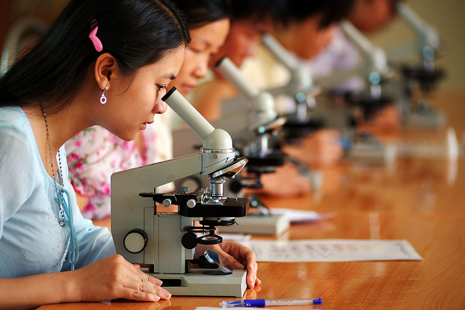 In Viet Nam, young women look through microscopes. Photo: UN Women/Pham Quoc Hung