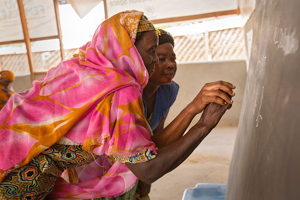 A woman in a refugee camp in Cameroon learns to write. Credit: UN Women/Ryan Brown