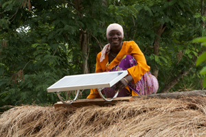 L’ingénieure en énergie solaire, Arafa Mwamba Halfani, de Chekeleni, après avoir installé un des panneaux solaires de 20 watt. Photo crédit: VSO/Ben Langdon.