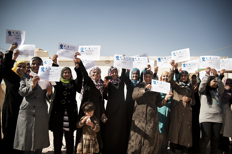 The first Syrian women graduates of the “Women and Girls Oasis” programme celebrate at the Za’atari Refugee Camp in Jordan. Photo credit: Ventura Formicone
