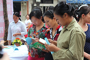 Women migrant workers read literature about their rights during the discussion on empowering migrant women with UN Women Asia-Pacific Regional Director Roberta Clarke in Ha Noi. Photo: UN Women/Thao Hoang